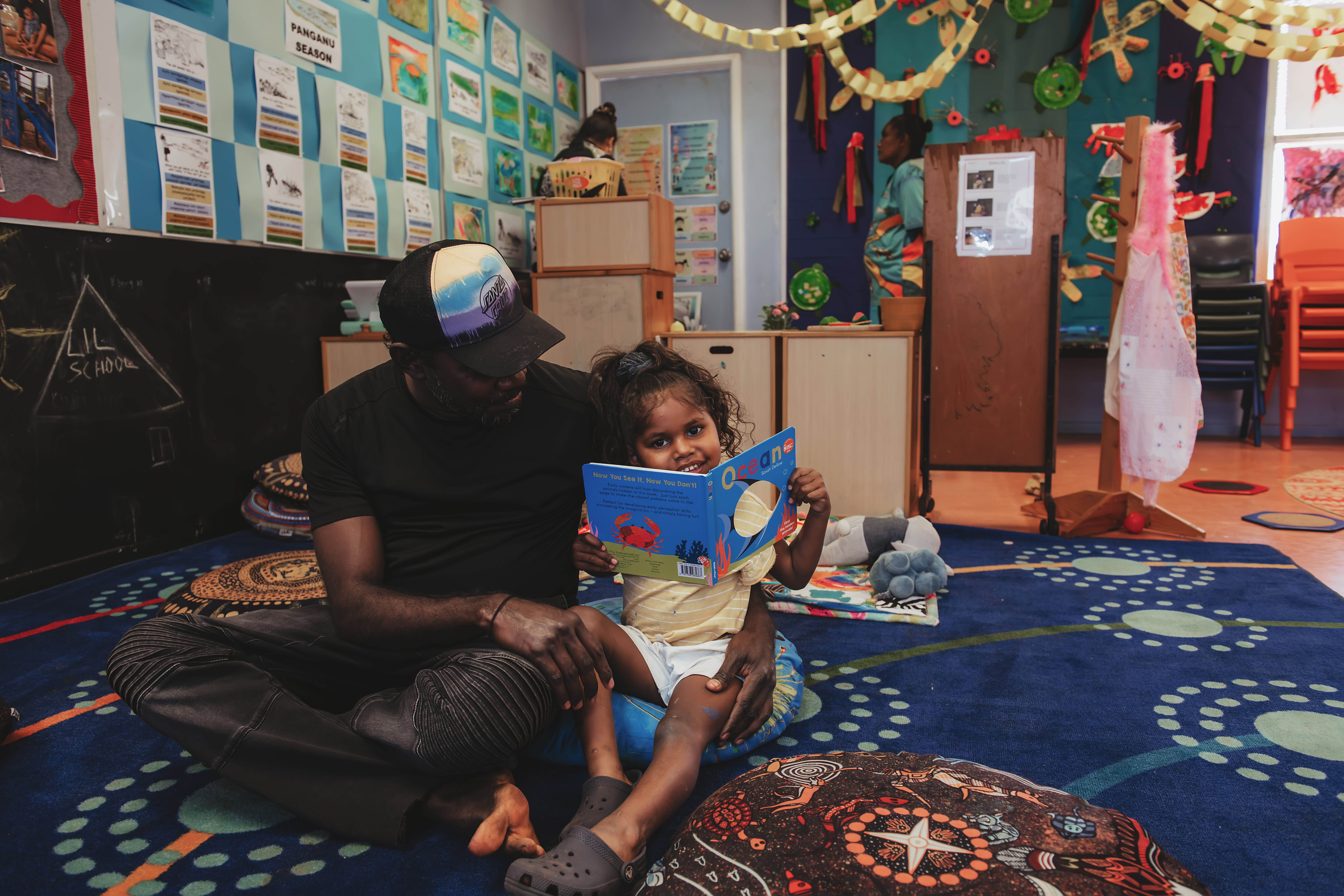 Young girl and carer reading a book