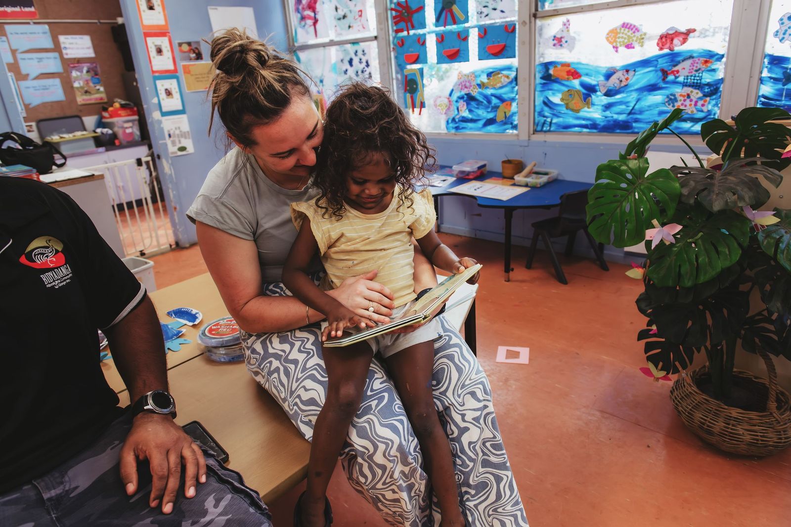 Young girl and carer reading a book